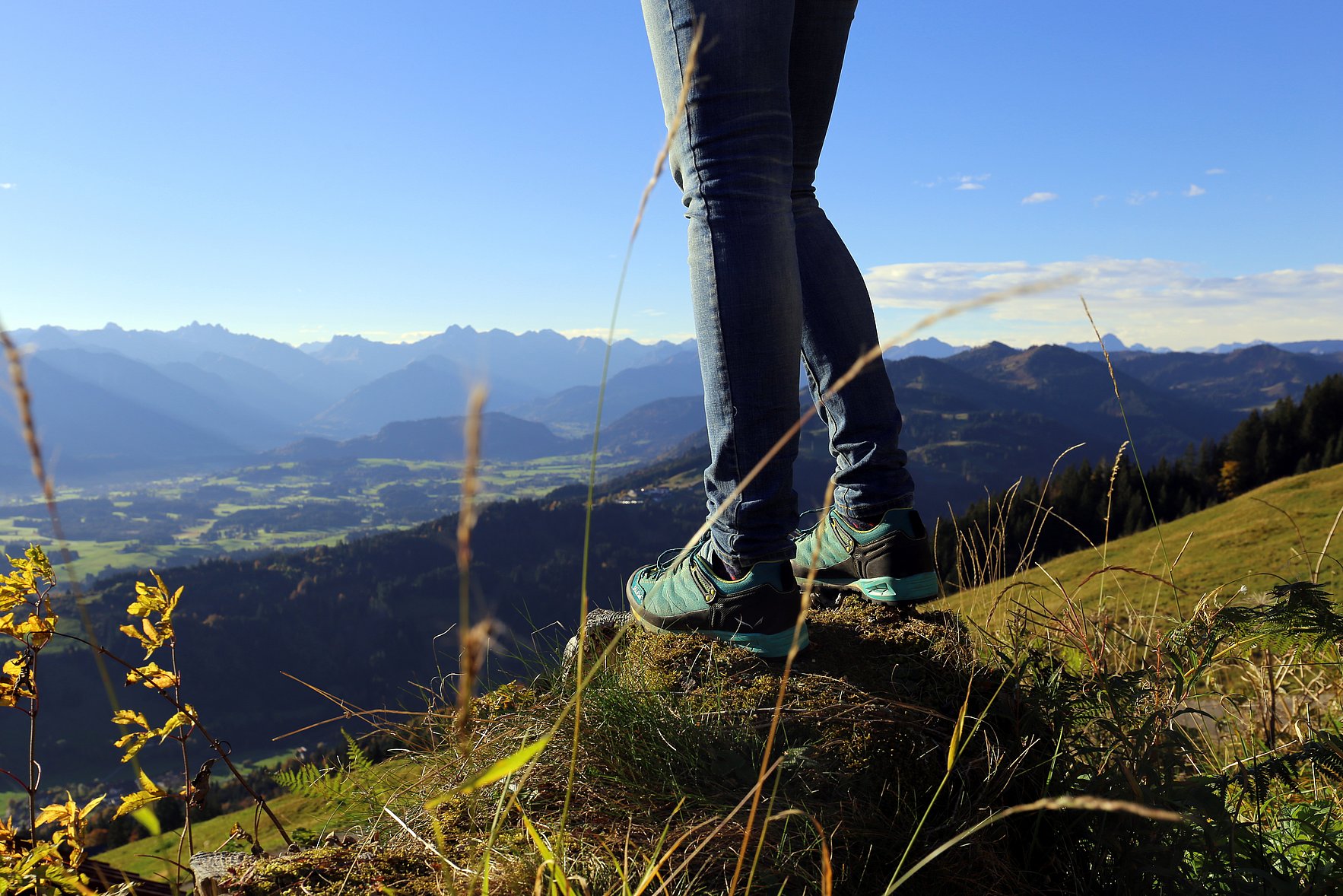 Ein Wanderer genießt den Ausblick auf das Tal und die Allgäuer Alpen.