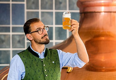 Inhaber Felix Widenmayer mit frisch gezapften Bier in der Hand in der Brauerei Engelbräu in Rettenberg.