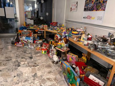 Eine Sammlung von Spielzeugen auf Holztischen in einem Raum. Verschiedene Spielsachen sind verstreut und bieten eine bunte Auswahl.