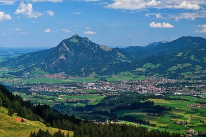 Der Blick von der Hörnerkette auf die Alpenstadt Sonthofen, die mit rund 22.000 Einwohner als südlichste Stadt Deutschlands gilt. Im Hintergrund befindet sich der Berg Grünten mit dem Sendeturm des Bayerischen Rundfunks. Am Fuße des Berges ist der Ort Burgberg zu erkennen. Sowohl der Berg als auch die zwei Ortschaften haben eine gemeinsame Geschichte im Eisenerzabbau vor rund 400 Jahren.