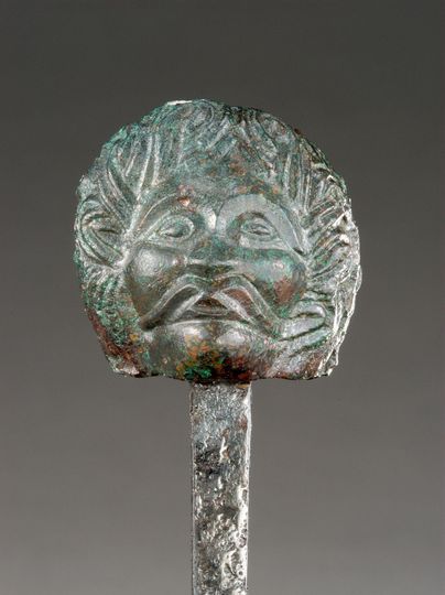 Eine bronzene Skulptur mit dem Kopf eines mythologischen Wesens. Der Gesichtsausdruck zeigt eine Mischung aus Ernsthaftigkeit und Stärke.