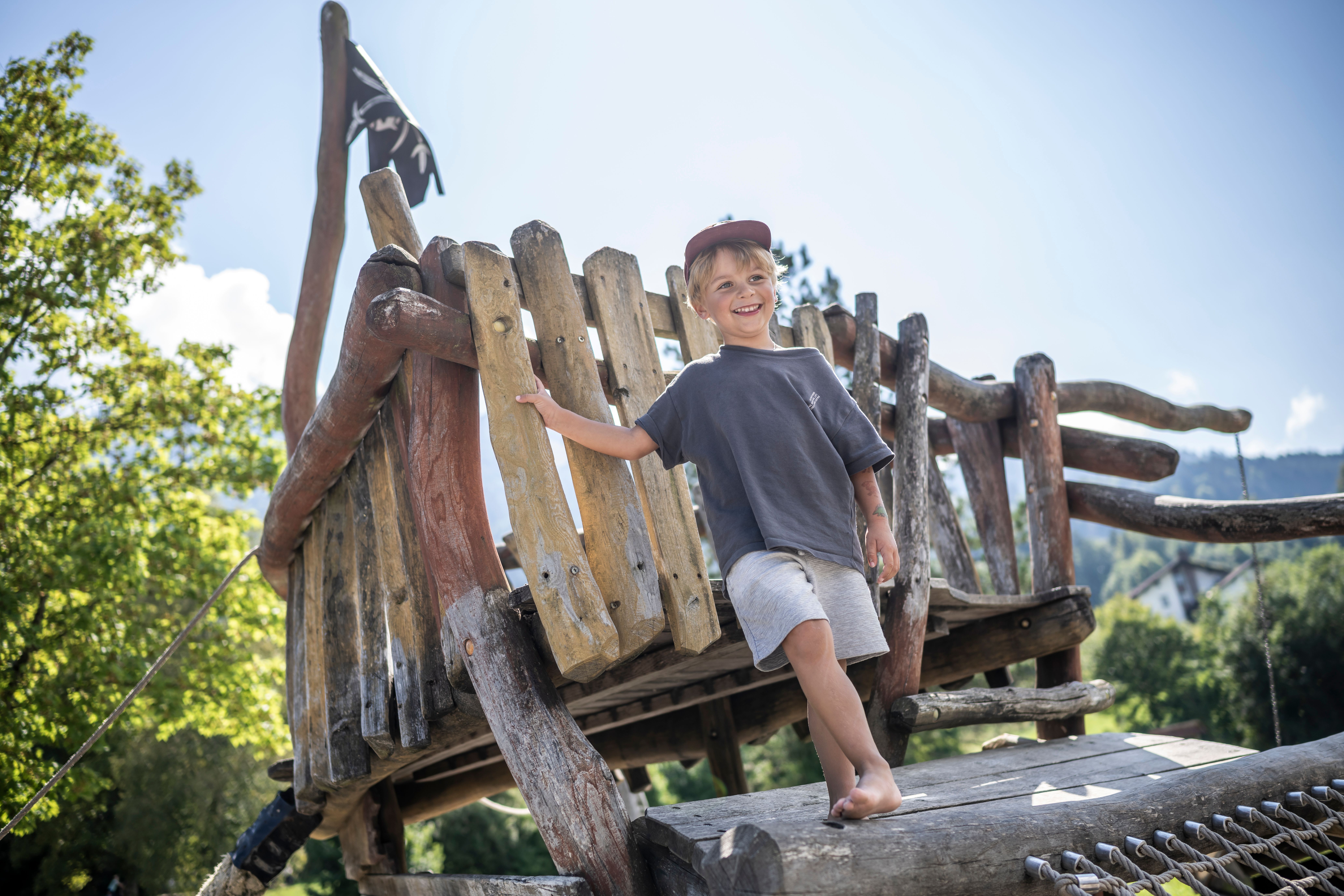 Ein Junge steht auf dem Klettergerüst des Piratenspielplatzes. Das Spielplatz-Gelände am Großen Alpsee bietet jede Menge Attraktionen für Kinder.