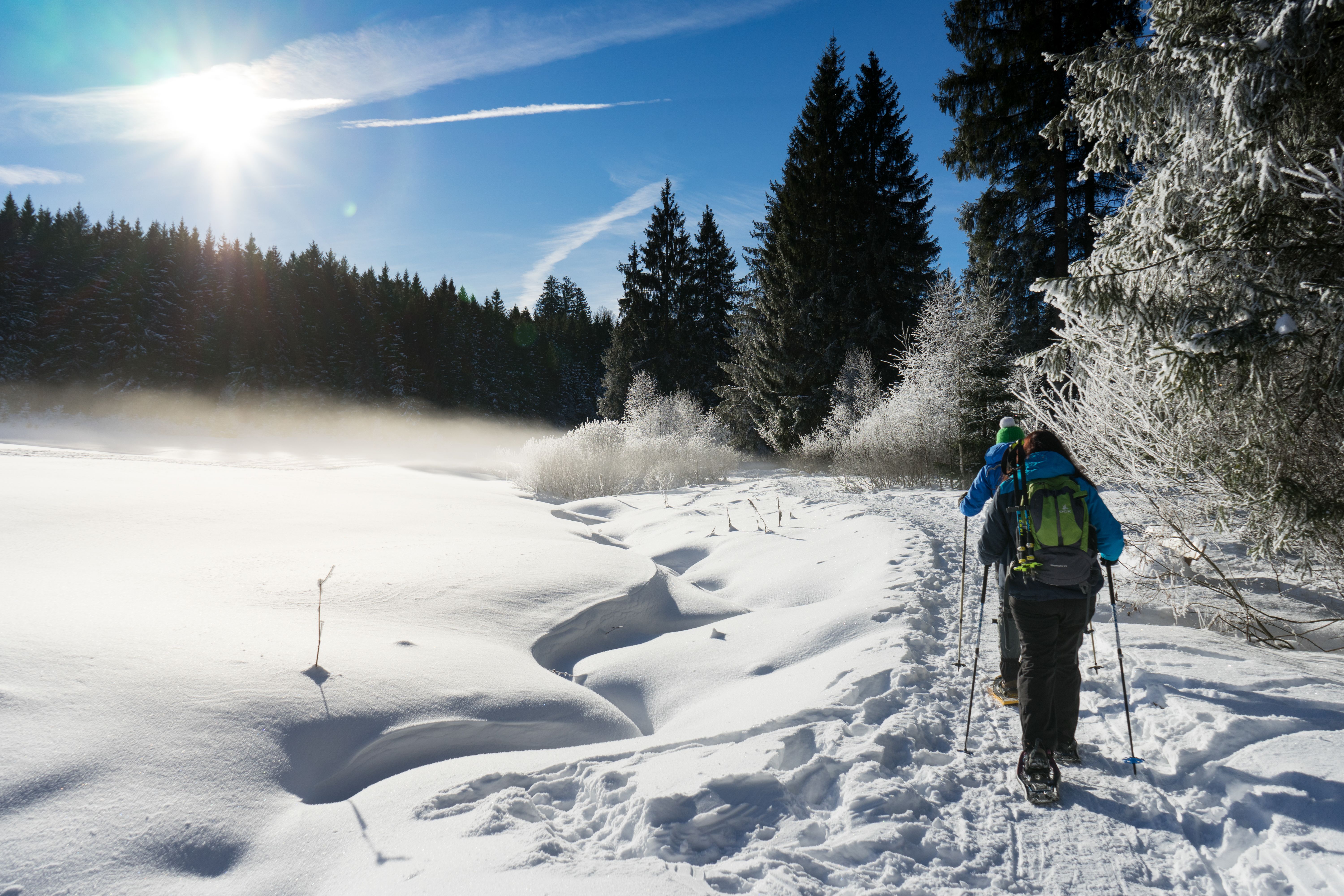 Zwei Schneeschuhwanderer gehen durch das schneebedeckte Schlettermoos zwischen Immenstadt und Missen. Dies bietet sich sehr gut als Ausgangspunkt für Wanderungen auf die Siedel-, Juget,- oder Pfarralpe an.