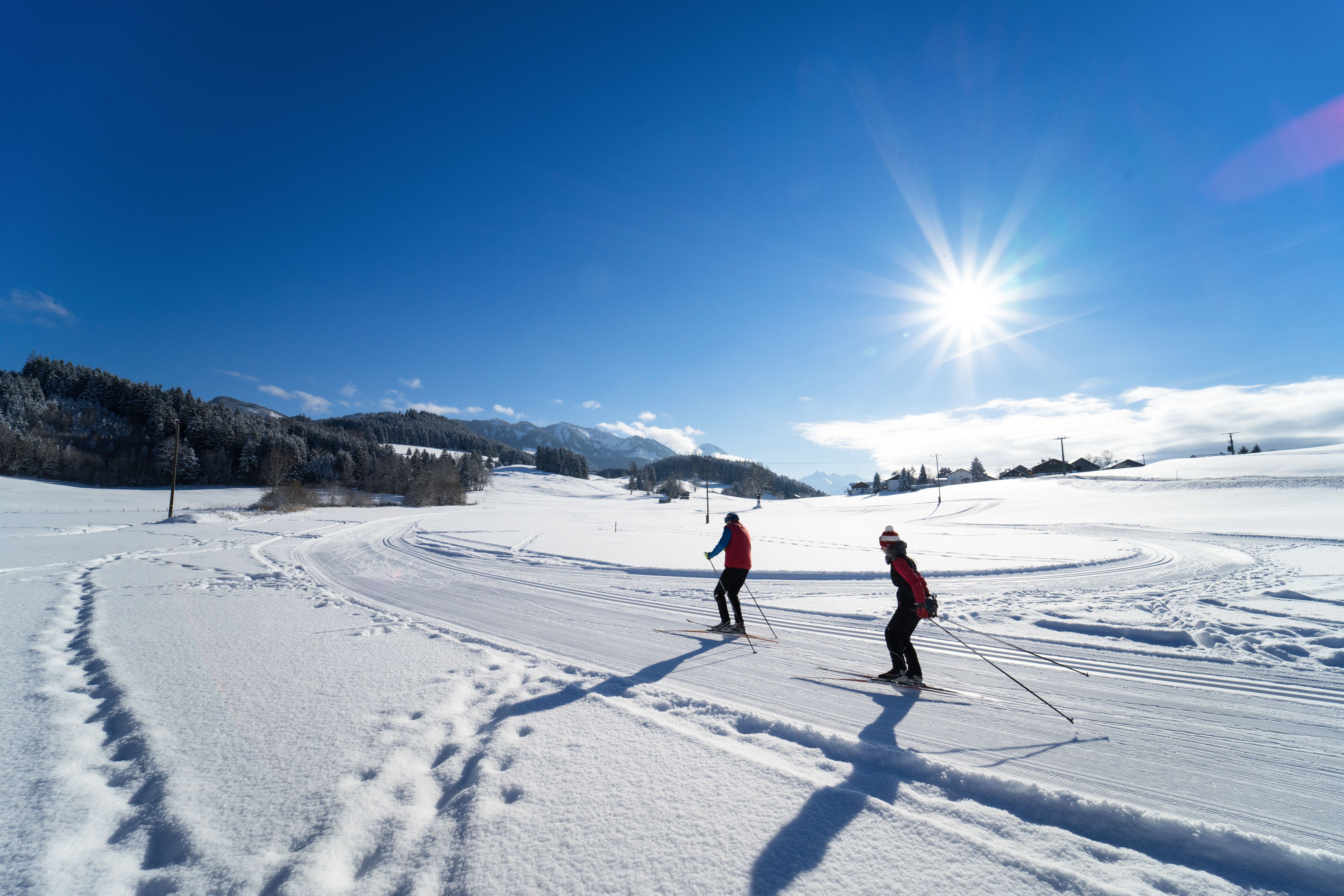 Zwei Personen fahren mit ihren Langlauf-Ski auf der Loipe im Sonthofener Ortsteil Hofen. Die Ferienregion Alpsee-Grünten ist ein wahres Langlauf-Paradies mit besonders zentral gelegenen, einsteigerfreundlichen Loipen für klassischen Langlauf sowie die freie Skating-Technik.