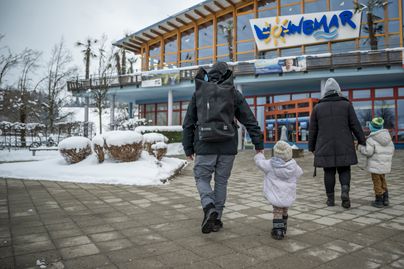Eine Familie besucht gemeinsam im Winter das Wonnemar in Sonhofen. Bein hineingehen halten die Eltern ihre Kinder an der Hand.