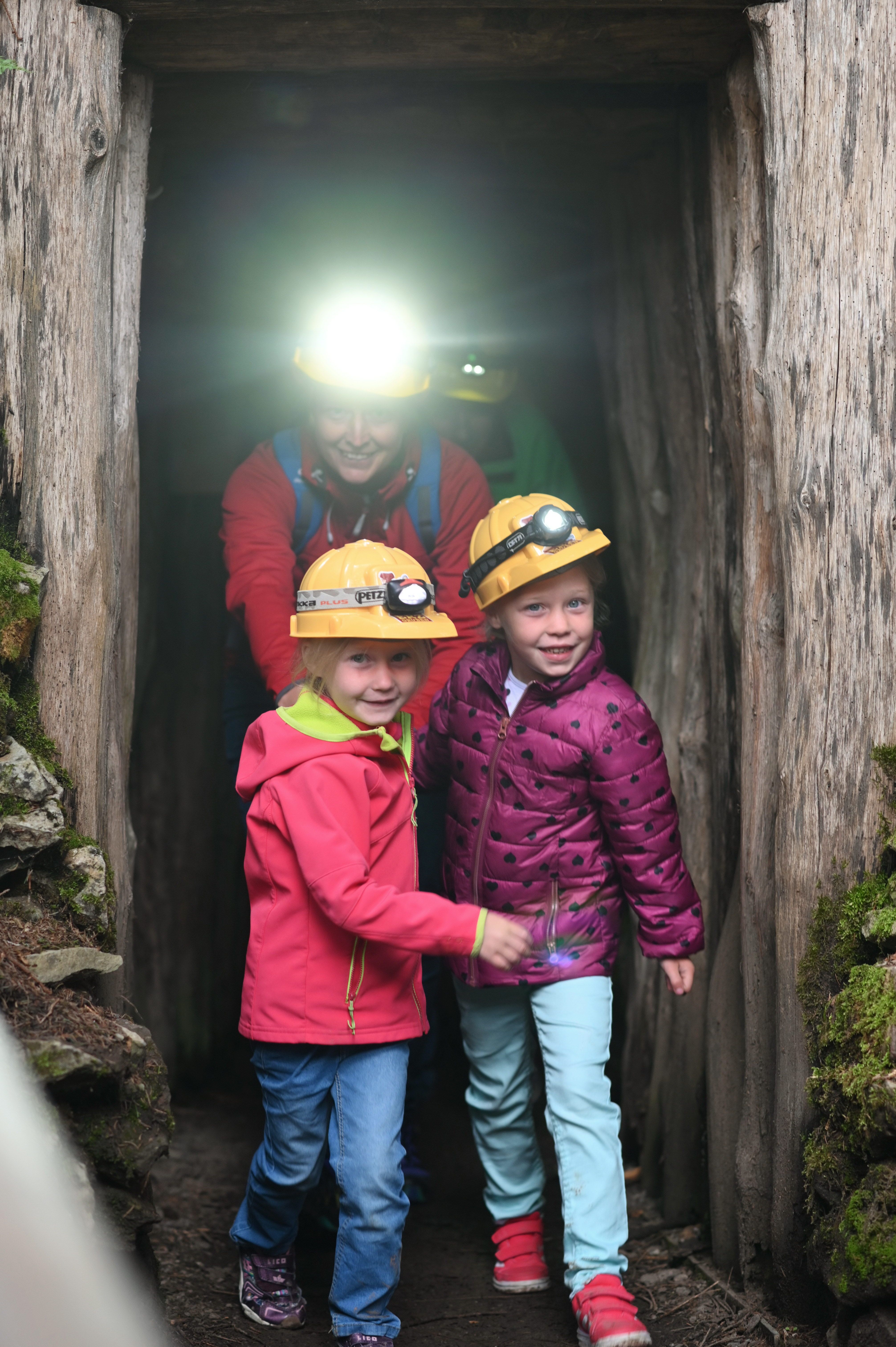 Mutter, Vater und zwei Mädchen kommen aus einer Grube in den Erzgruben in Burgberg. Die Familie nimmt an einer der spannenden Führungen teil.