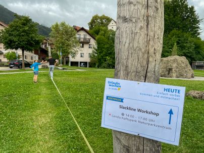 Im Landschaftspark Bühl befinden sich zwei Personen auf der Slackline im Rahmen eines Slackline Workshops während der Urlaubswochen im Städtle 