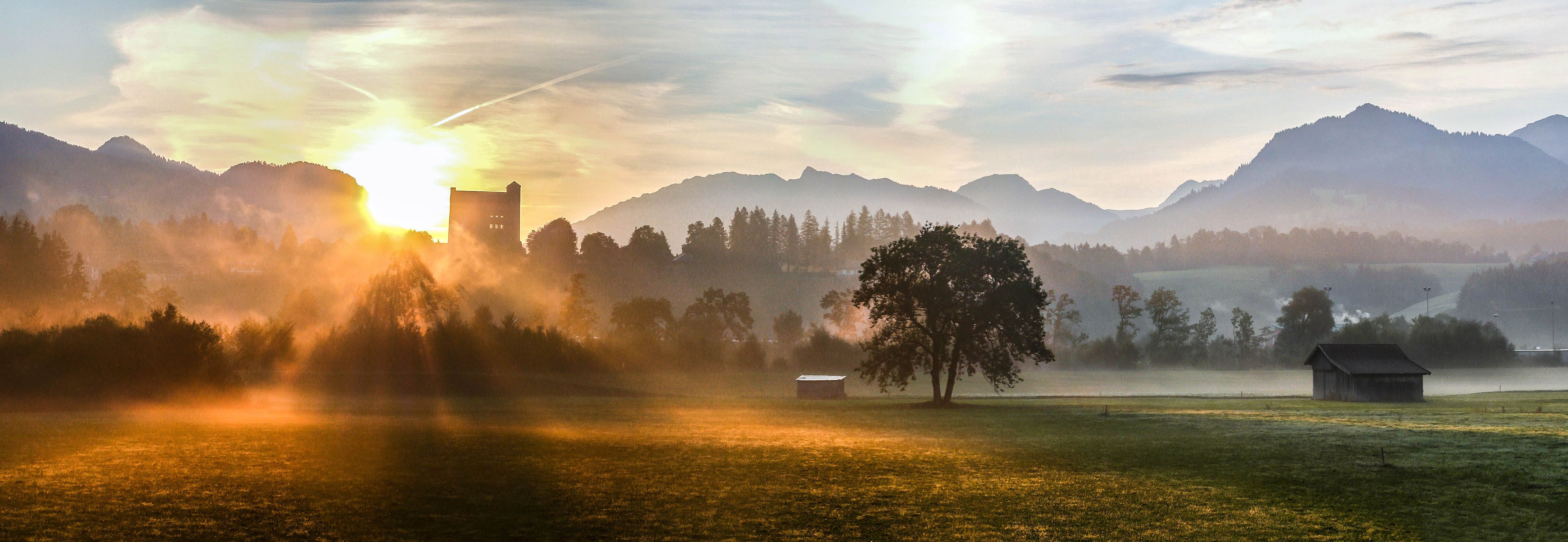 Die Sonne geht hinter der so genannten "Burg" in Sonthofen auf. Der Nebel legt sich über die davor liegenden Wiesen und Wälder. Hochaufragend über Sonthofen kann man schon von weitem den Turm der ehemaligen "Ordensburg Sonthofen", heute "Generaloberst-Beck-Kaserne", sehen, der nur einen kleinen Teil des großen Komplexes auf dem Berg über der Stadt darstellt.