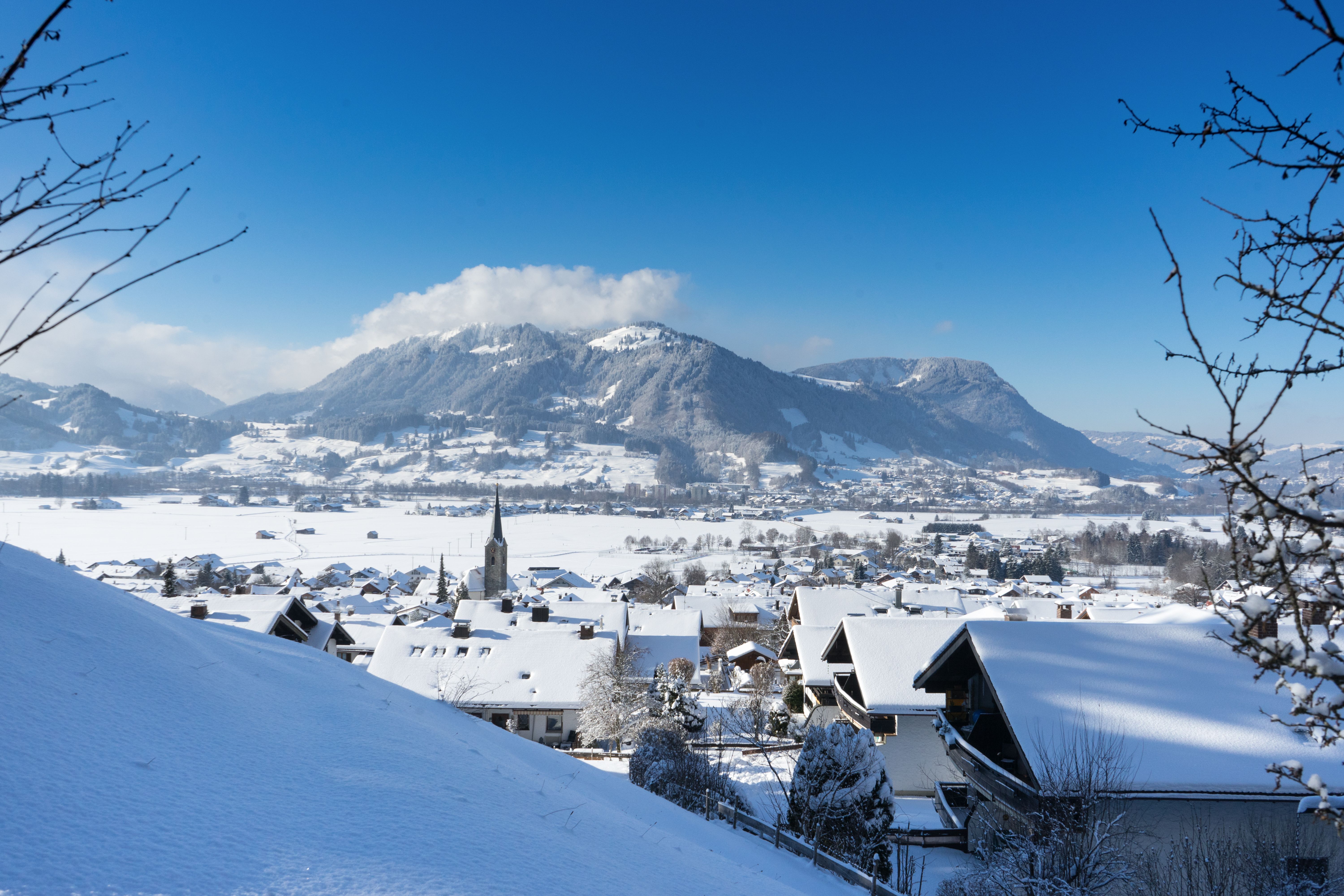 Blick über Burgberg im Winter, im Hintergrund liegt Blaichach und der Mittagberg. Burgberg liegt am Fuße des Grüntens auf ca. 750 Höhenmetern.