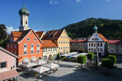 Das Bild zeigt die Stadt Immenstadt mit der Stadtpfarrkirche St. Nikolaus im Winter. Im Hintergrund sind die Berge des Naturparks Nagelfluhkette zu sehen