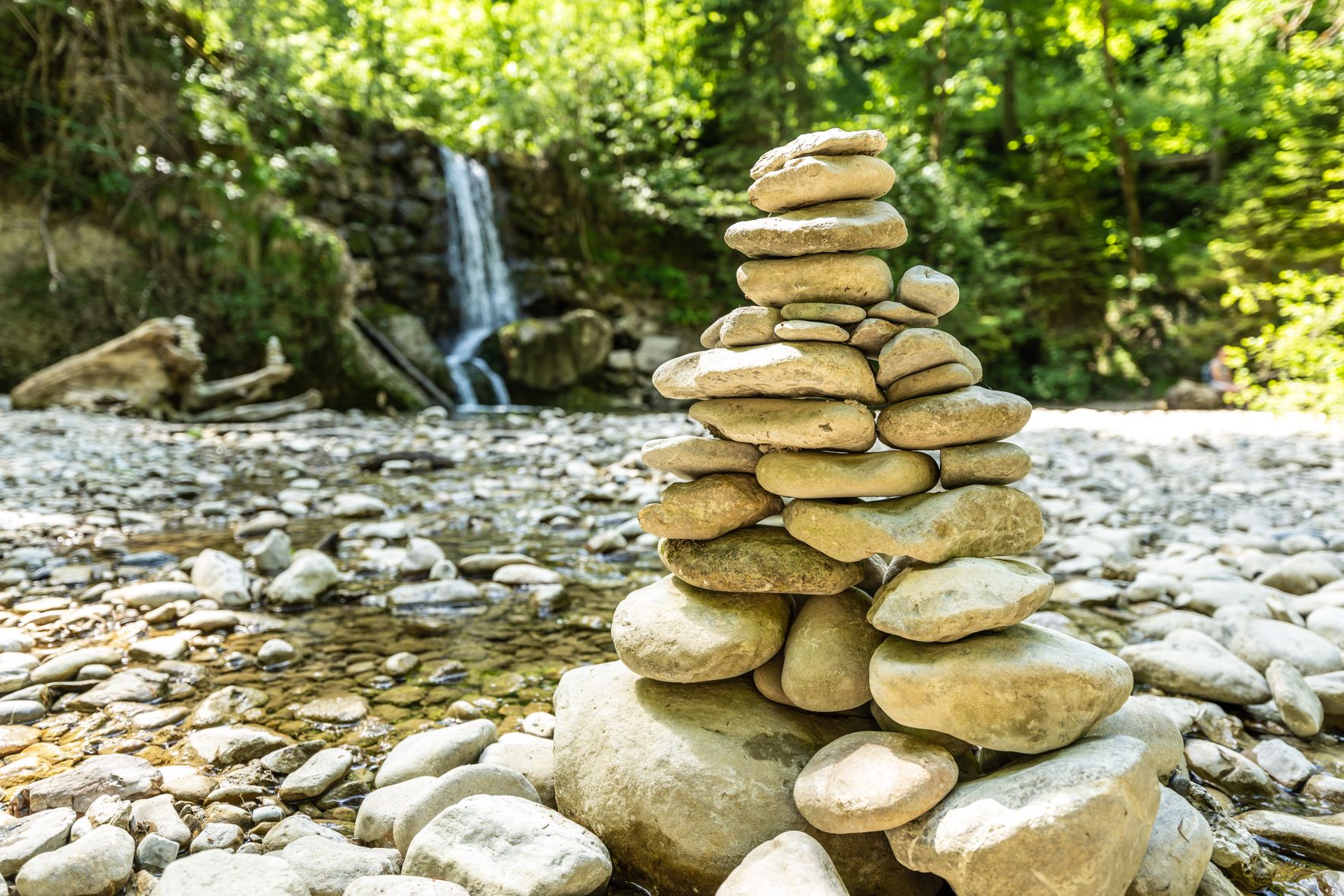 Am Fuße eines kleinen Wasserfalls im Steigbachtobel bei Immenstadt steht ein großes Steinmännle.