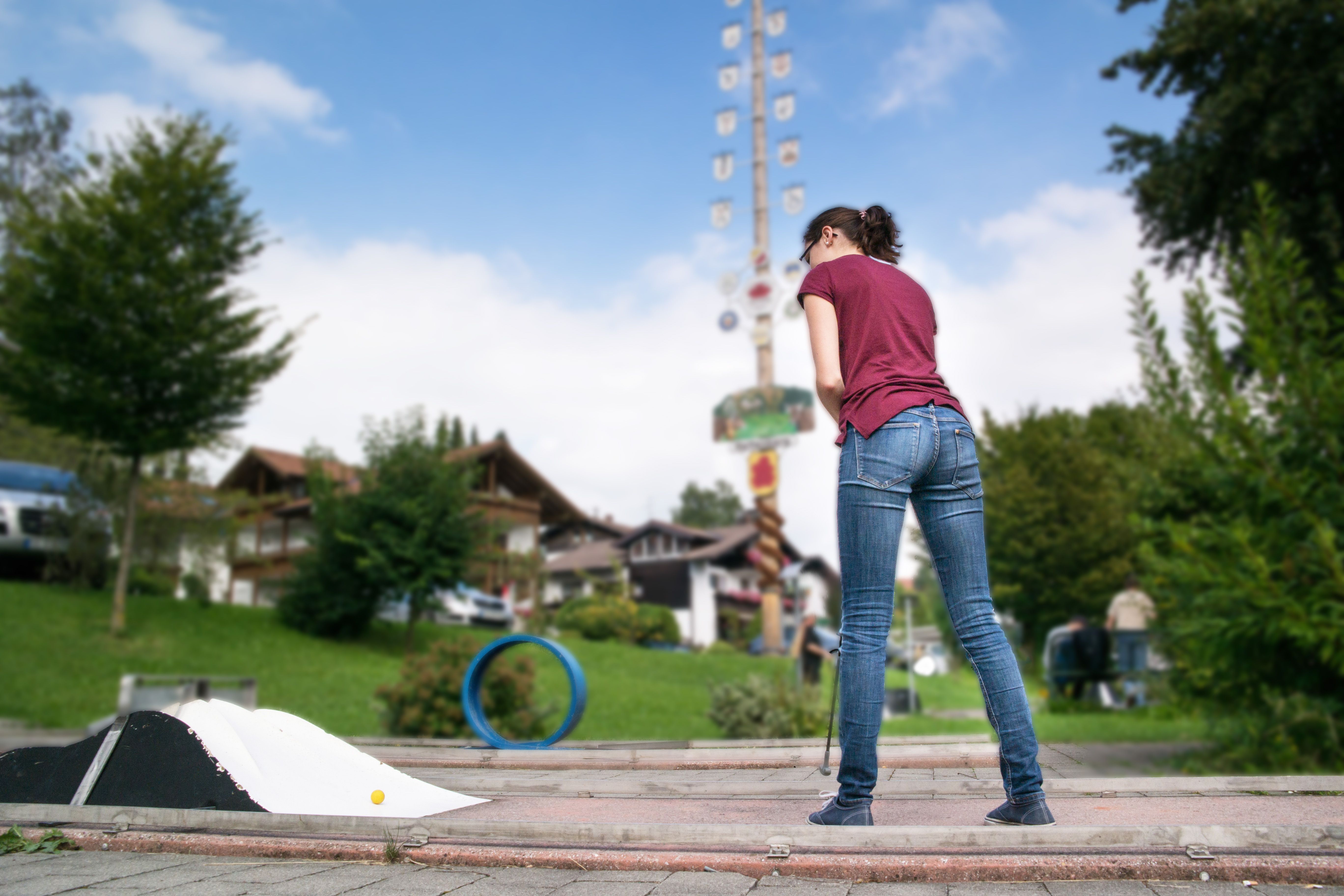 Eine Frau spielt Minigolf in Rettenberg. Auf dem 18-Lock-Platz spielt man stets mit dem Grünten im Blick.