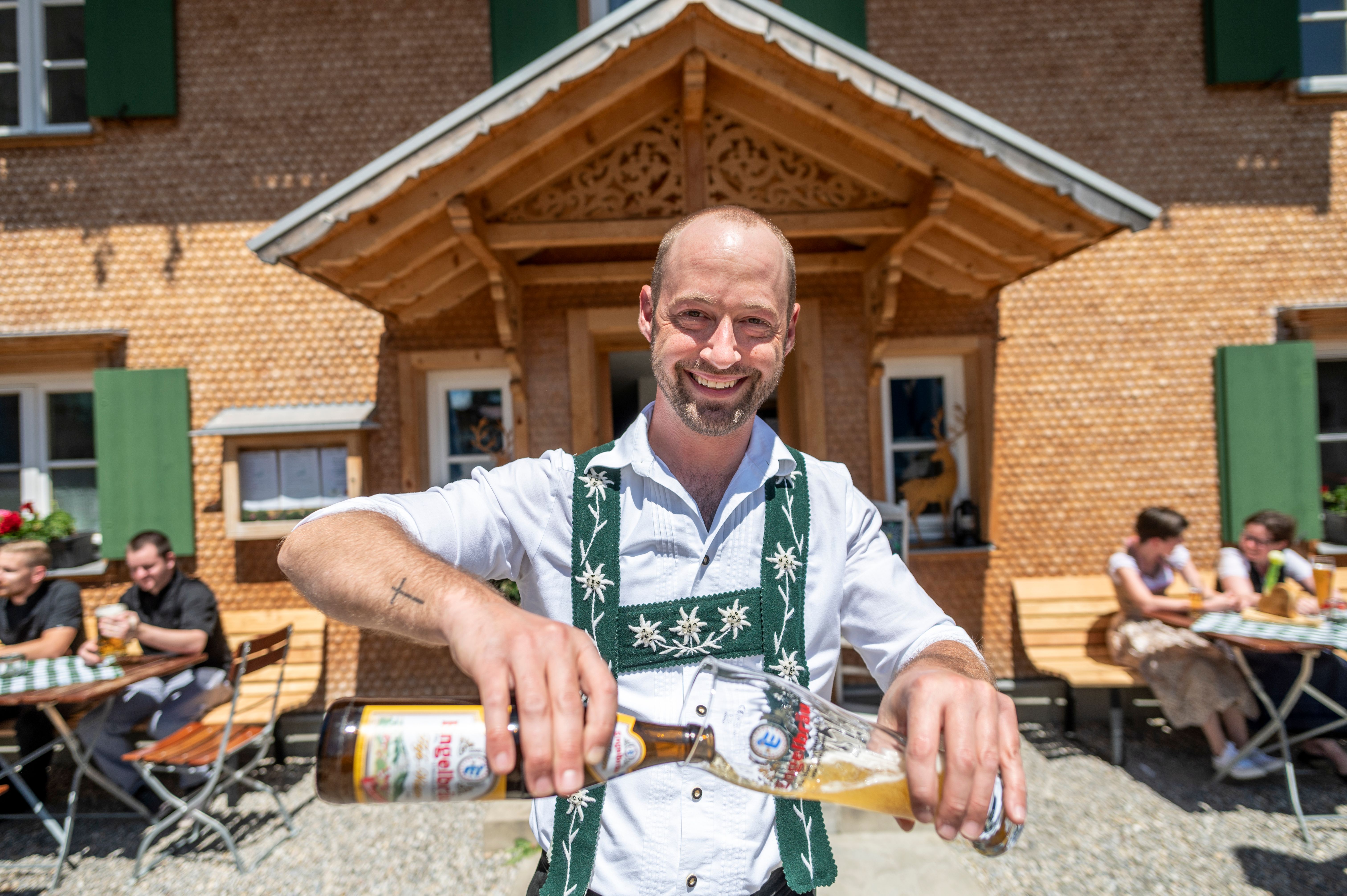 Der Wirt vom Gasthof Hirsch in Vorderburg (Rettenberg) schenkt demonstrativ einen "Weizen" - ein typisches bayerisches Biergetränk ein. Das besondere am Gasthof Hirsch ist, dass dieser durch die Dorfgemeinschaft Vorderburg finanziert und betrieben wird, um den Dorfmittelpunkt und die Gastronomie im Ort zu erhalten.