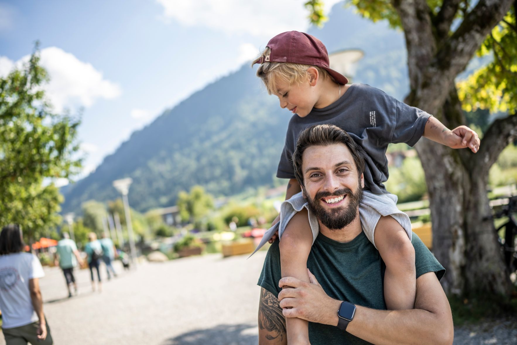 Wenn die ganze Familie einen Tag am Alpsee verbringt sind alle glücklich. Der Sohn hat auf Papas Schultern oben eine gute Aussicht.
