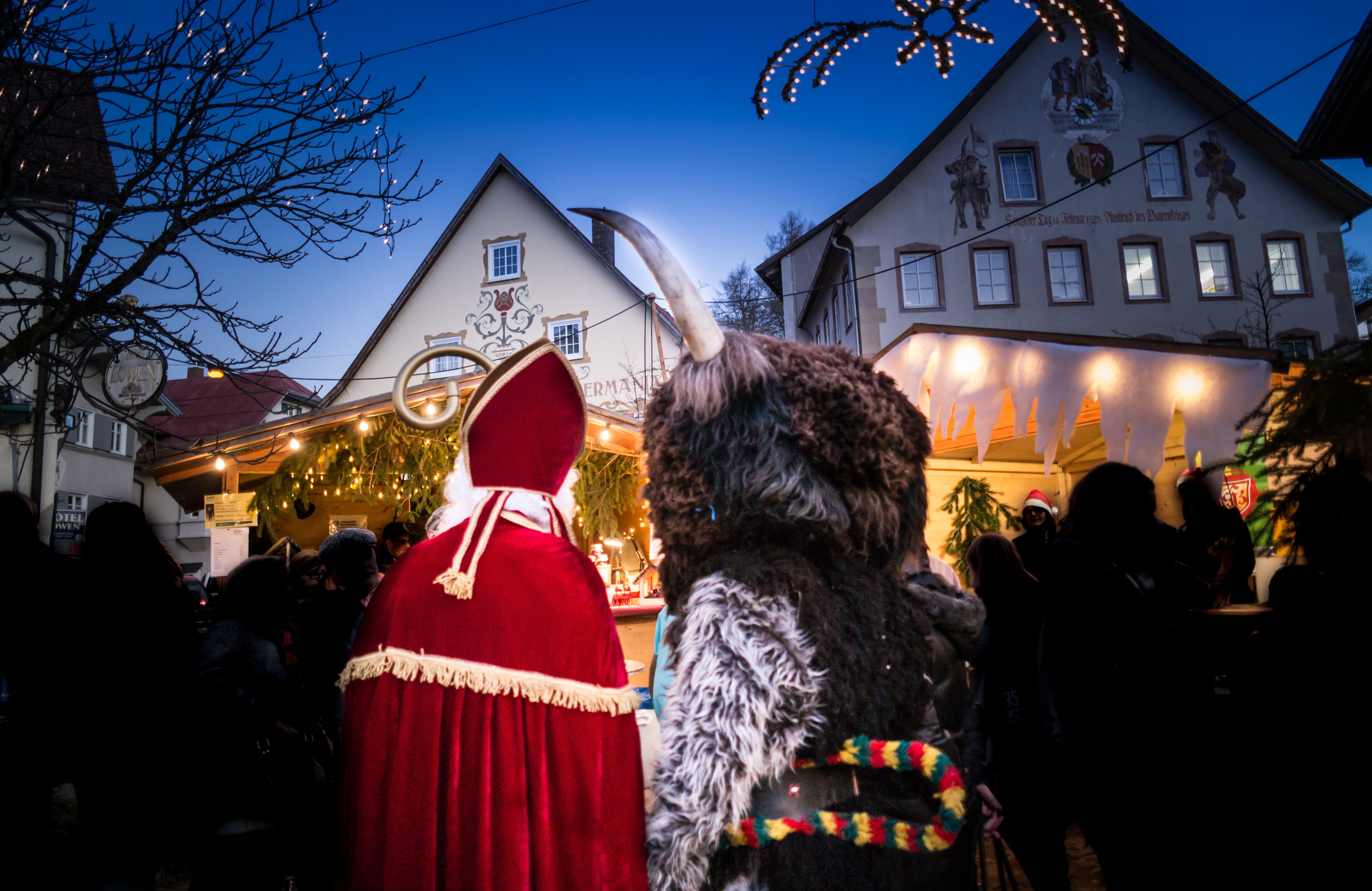Auf dem Christkindlesmarkt in Sonthofen stehen neben vielen Besuchern der Heilige Nikolaus und Knecht Rubrecht.