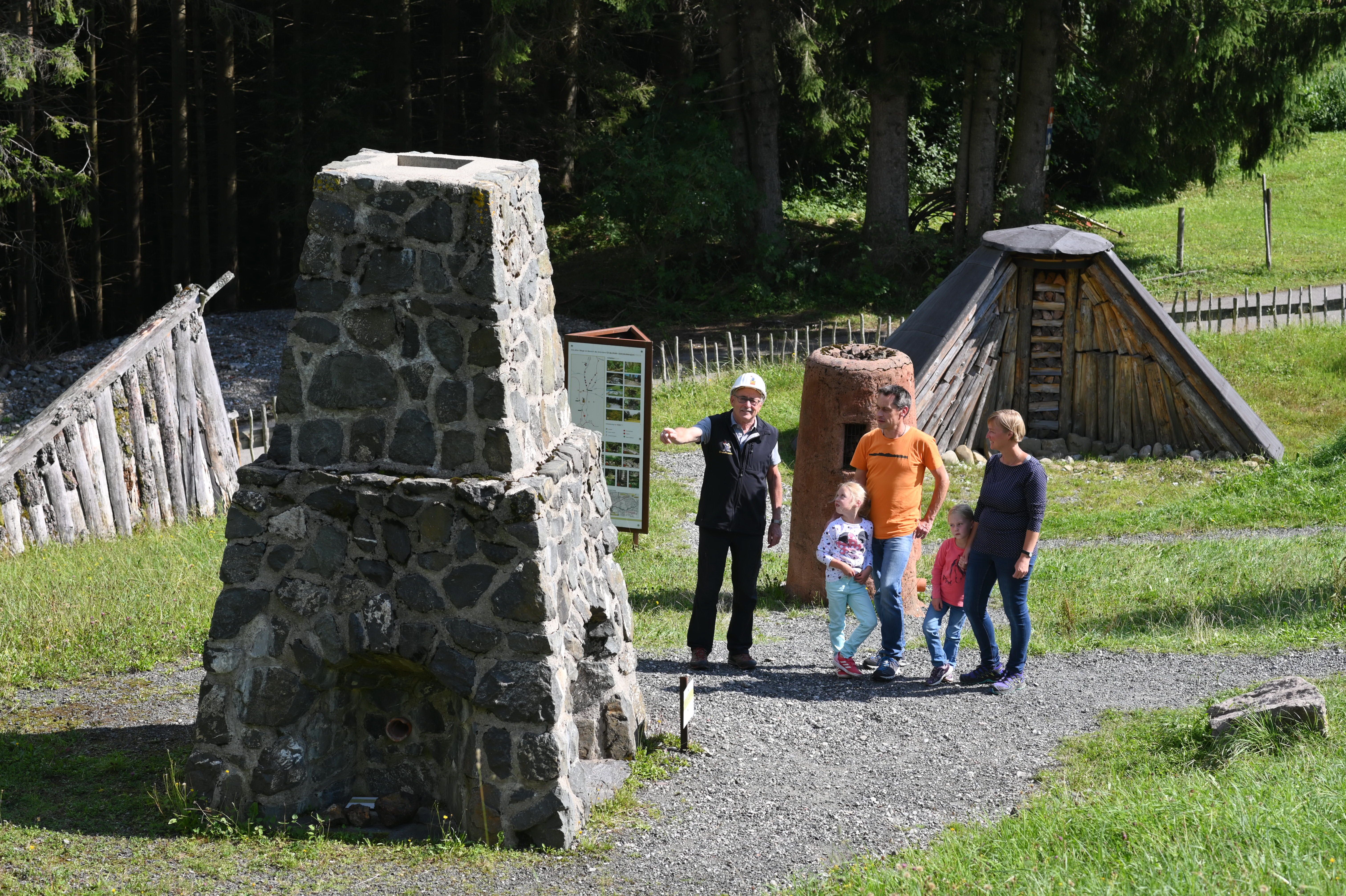 Eine Familie nimmt in den Erzgruben in Burgberg an einer Führung teil. Mutter, Vater und zwei Mädchen hören aufmerksam dem Führer zu.