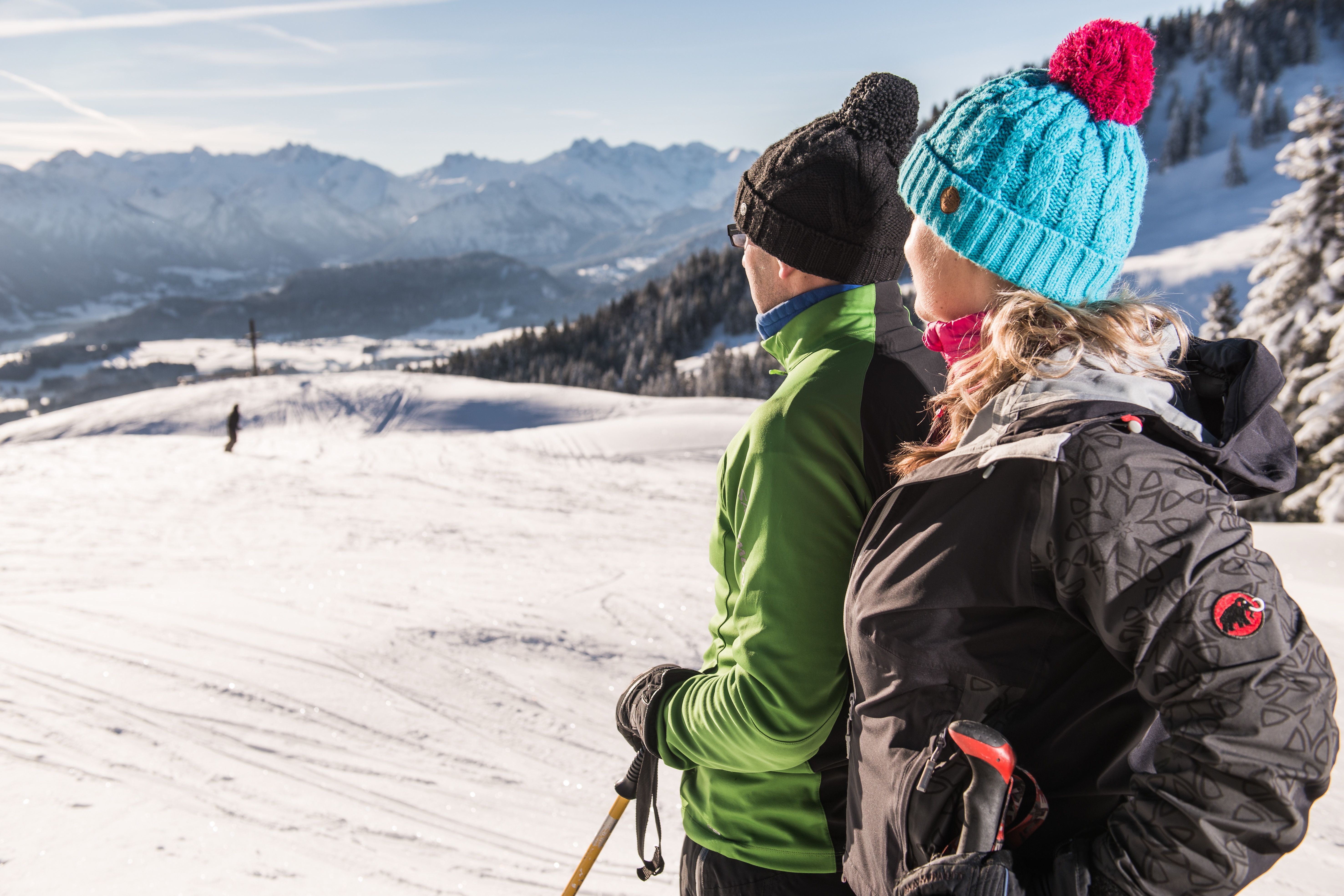 Zwei Skitourengeher blicken auf dem Ofterschwanger Horn zum Gipfelkreuz. Der Berg liegt über der Gemeinde Ofterschwang und südlich von Gunzesried (Blaichach). Als nördlichster Gipfel der Hörnergruppe hat er eine Höhe von 1.406 Metern.
