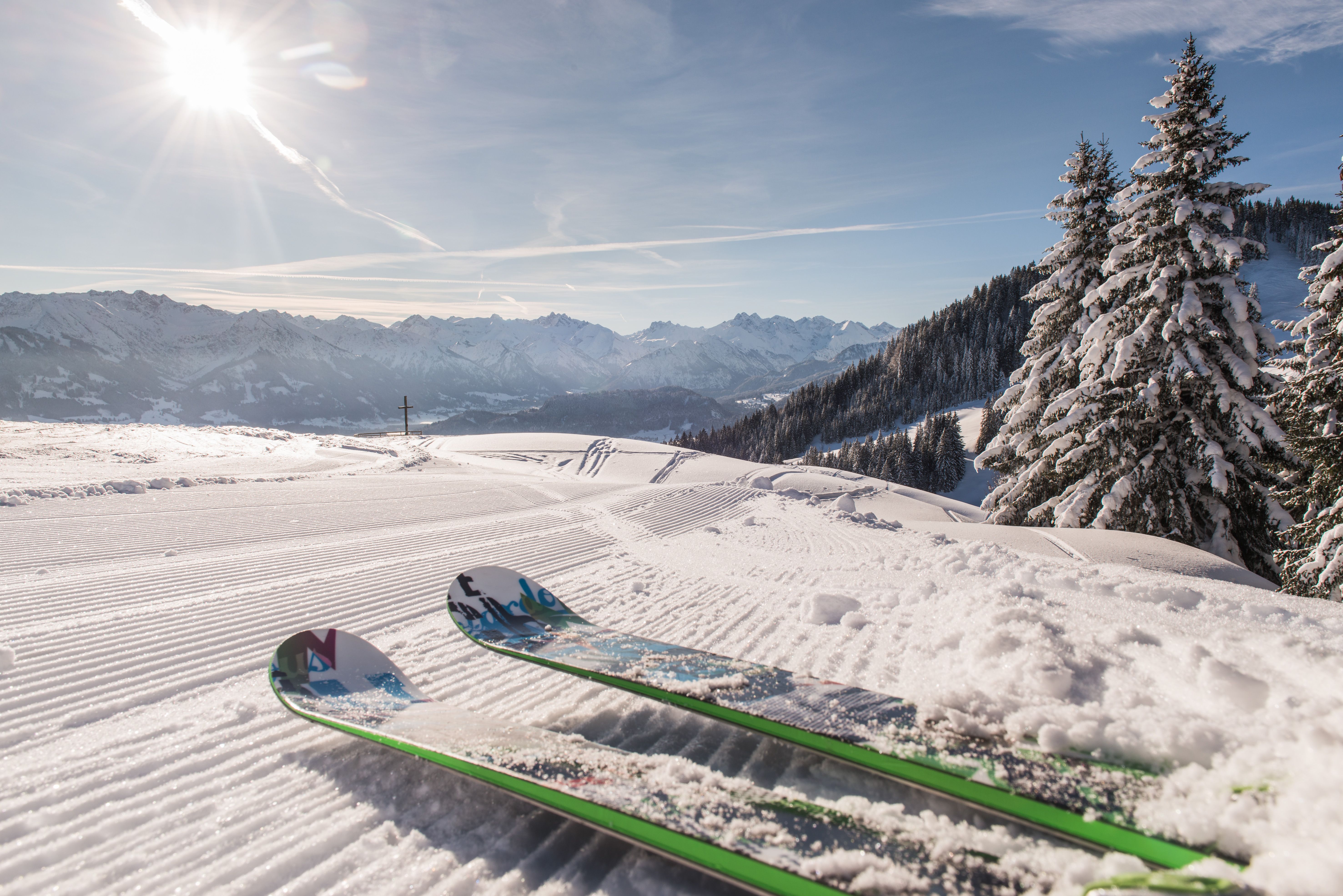 Ein Paar Ski kreuzt die Piste des Familien-Skigebiets der Bergbahnen Ofterschwang-Gunzesried. Das Skigebiet am Ofterschwanger Horn bietet Wintersport in allen Facetten. Mit den familiengeeigneten Pisten und Kinderübungsgeländen ist es sowohl für Anfänger als auch für geübte Skifahrer das perfekte Skigebiet.