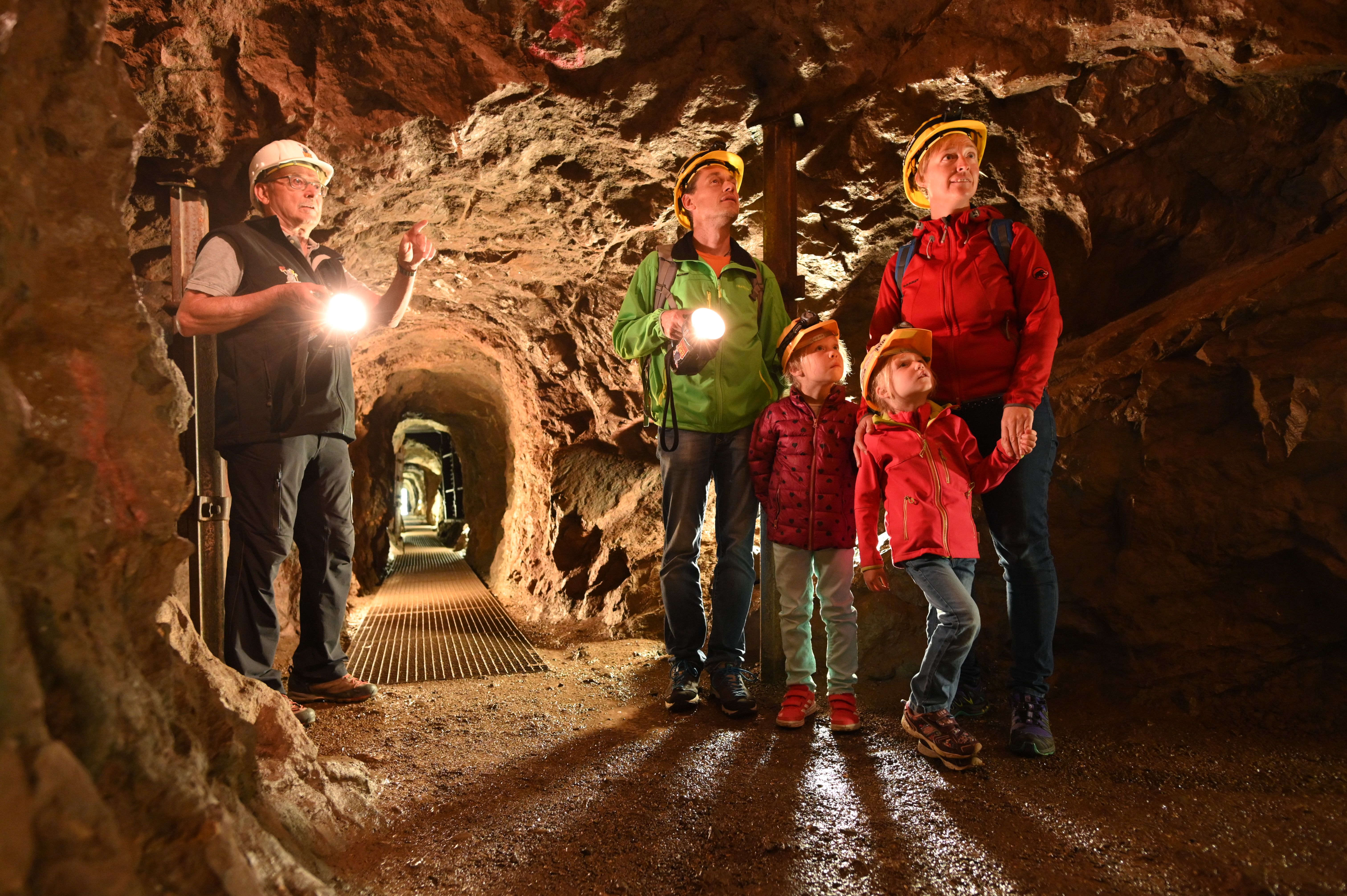 Zwei Kinder machen mit ihrem Papa und ihrer Mama einen Ausflug in die Erzgruben. Besonders für Familien ist eine Führung durch die Stollenanlage ein tolles Abenteuer.