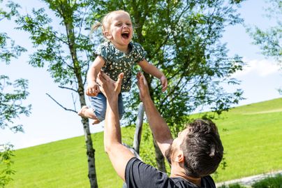 Ein Vater und seine Tochter spielen auf dem Naturspielplatz Hasengarten in Rettenberg.