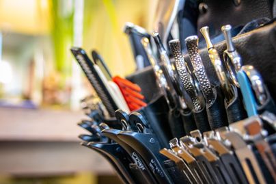 Eine Nahaufnahme von Friseurwaffen in einem Haarsalon. Die Werkzeuge sind ordentlich in einem schwarzen Etui angeordnet.