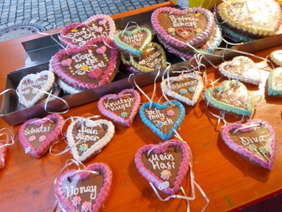 Eine Auswahl bunter Lebkuchenherzen mit süßen Botschaften. Die Herzen sind auf einem Tisch arrangiert und haben bunte Zuckerglasuren.