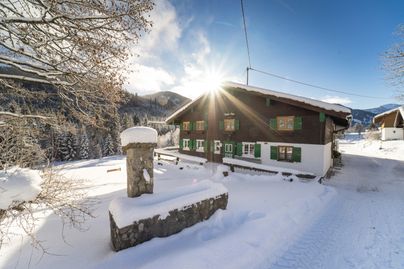 Die Buhl`s Alpe in Gunzesried im Winter, mit schneebedecktem Dach und Terasse.Das Ostertal bietet sich im Winter als perfekte Ausganslage für Schneeschuh- oder Skitouren an. Danach lädt die Buhl´s Alp zur Einkehr ein.