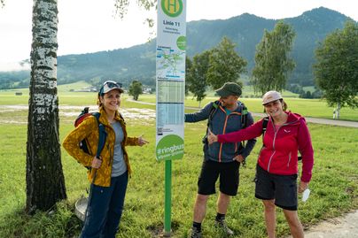 Drei Fahrgäste warten auf den Ringbus am Goymoos Kreisverkehr bei Rettenberg.
