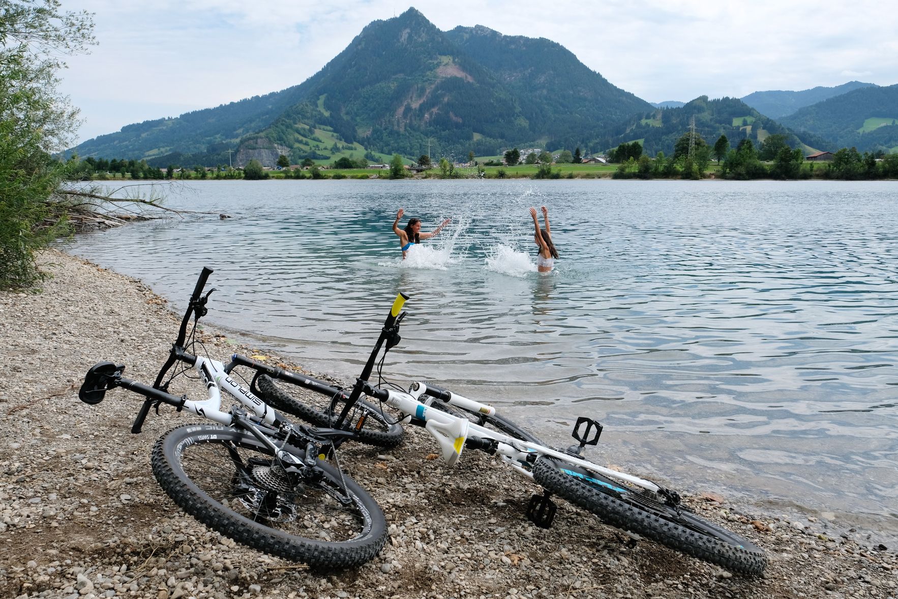 Zwei Radfahrerinnen genießen nach einer Fahrradtour eine Abkühlung im Ortwanger See.