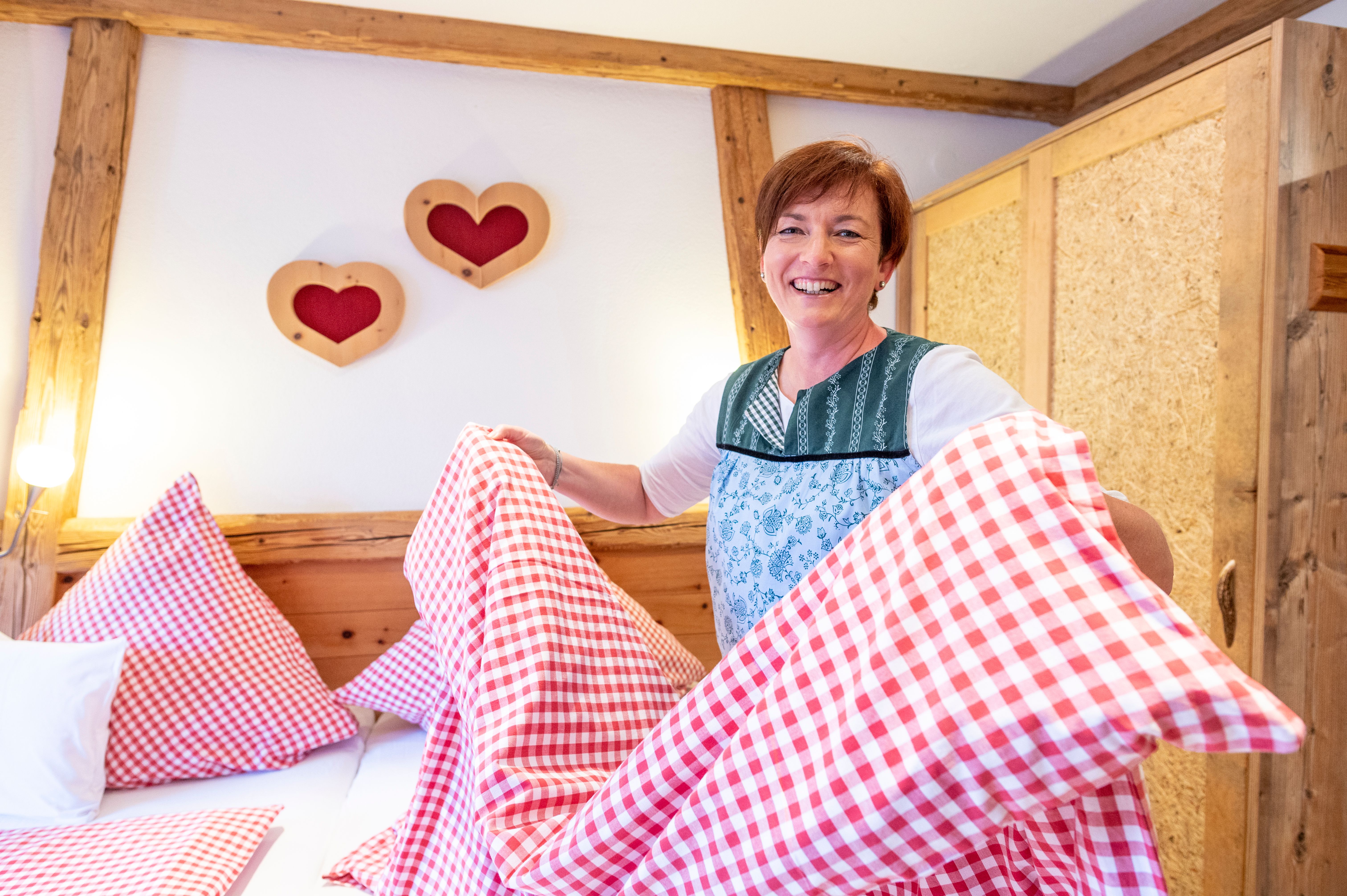 Eine Gastgeberin macht lächeln die Betten in ihrer Ferienwohnung.